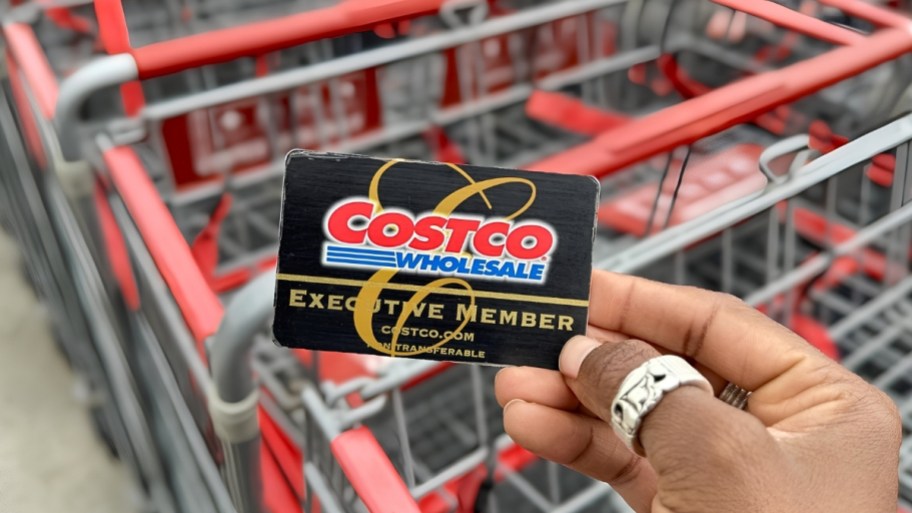 a womans hand holding a Costco membership card