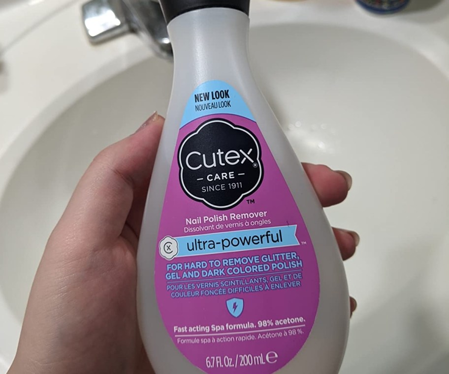 holding a bottle of nail polish remover