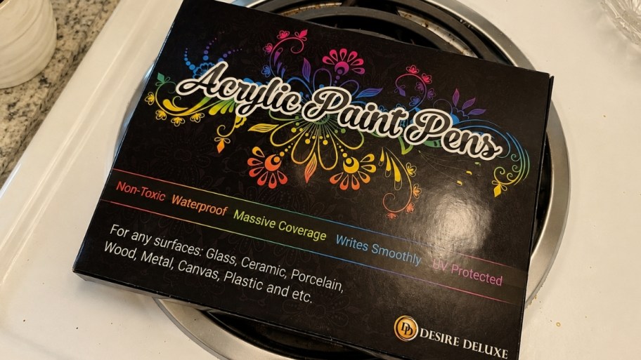 a box of acrylic paint pens on a stove top