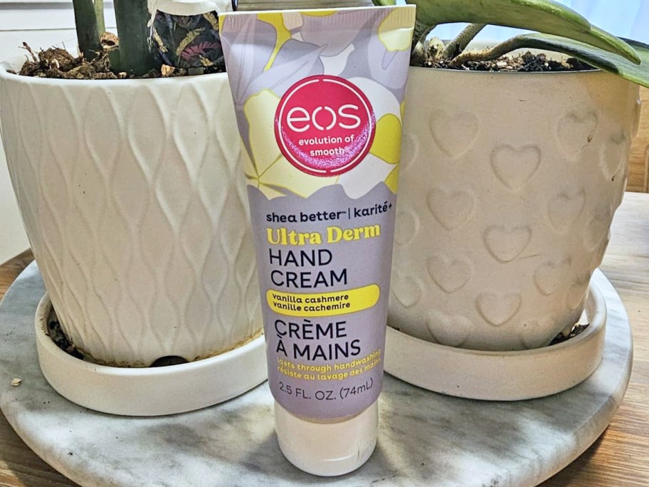 tube of eos Vanilla Cashmere Hand Cream near two potted plants