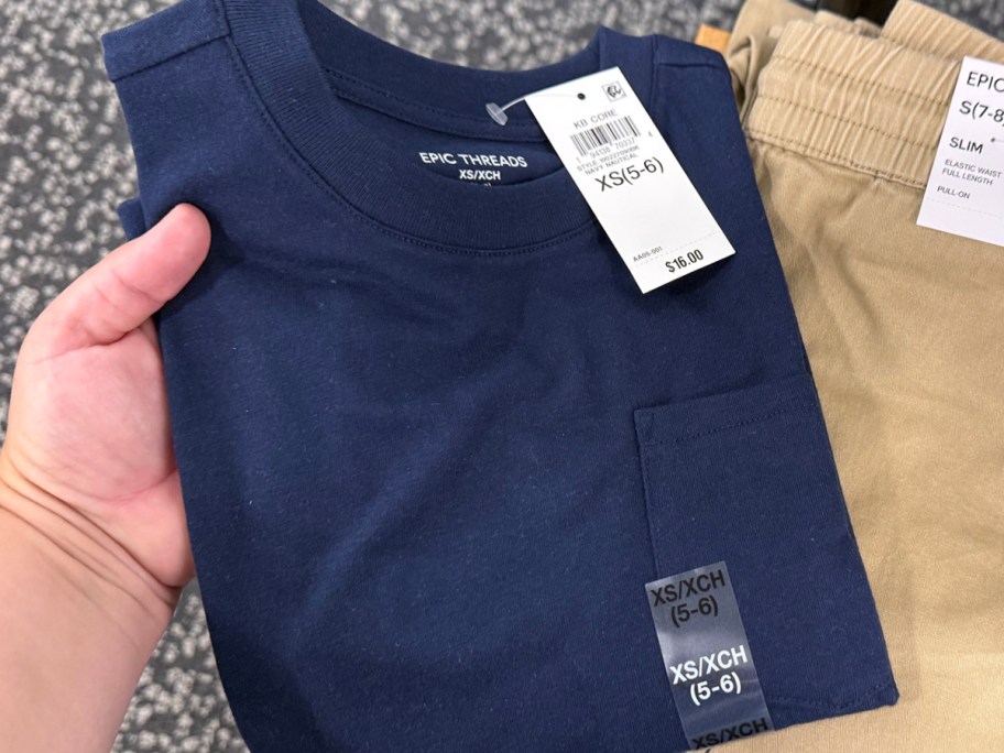 hand holding blue tee