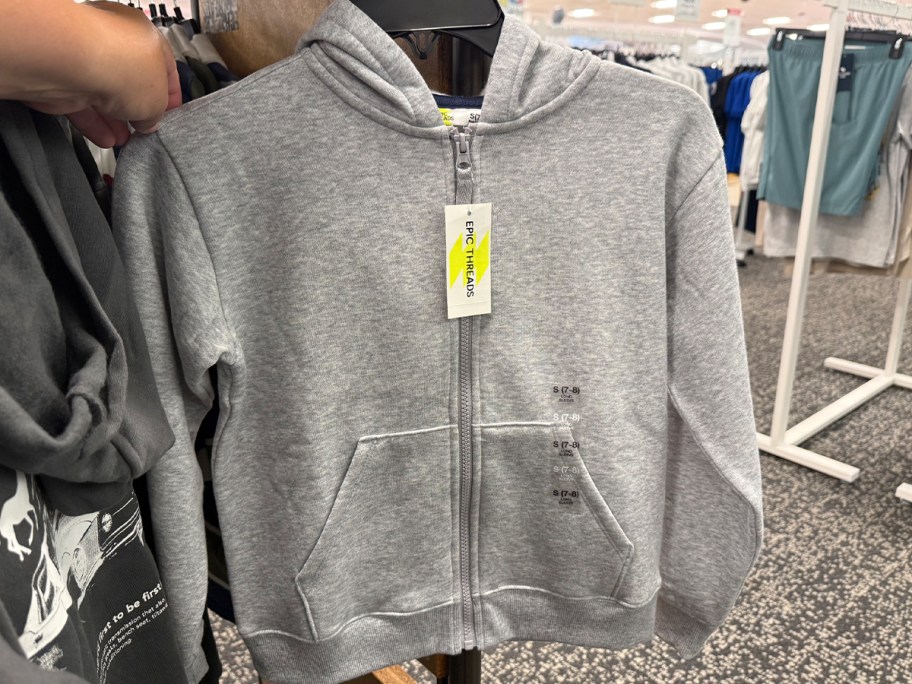 hand holding gray hoodie 