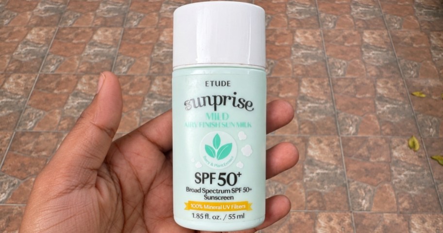 hand holding a bottle of Etude suncreen