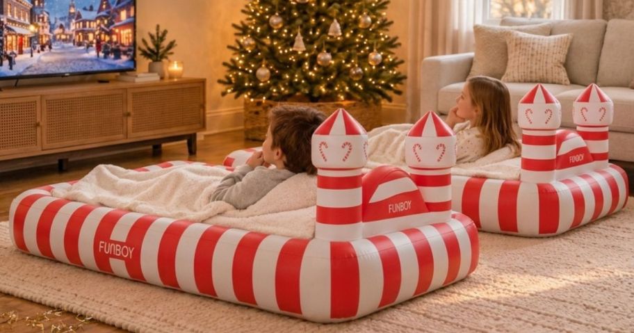 2 kids in candy cane air mattresses in a living room
