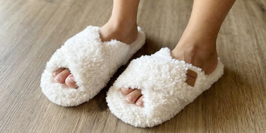 person wearing white slippers on hardwood floor 