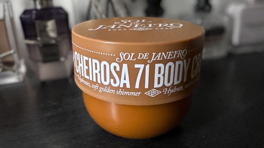 a jar of shimmering body cream on a vanity top