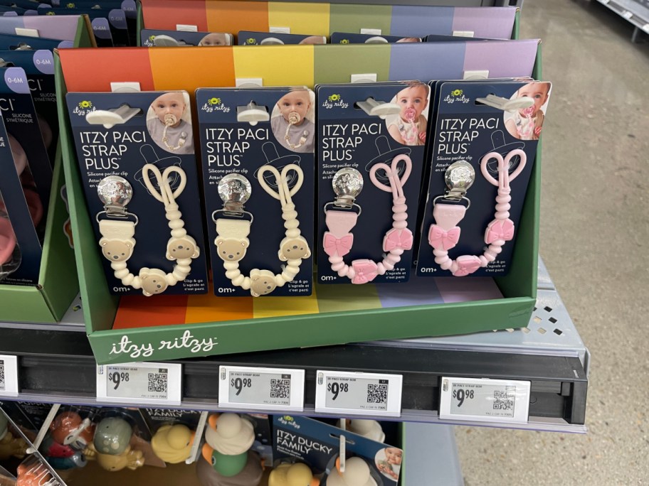 Itzy Ritzy brand pacifier straps in their packaging on a store shelf.