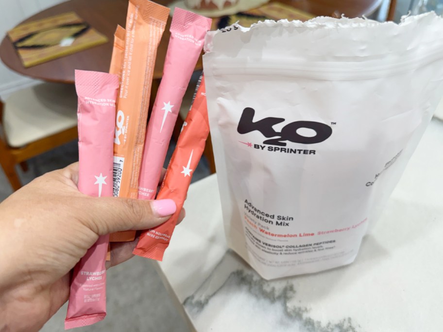 hand holding hydration packs and bag on counter