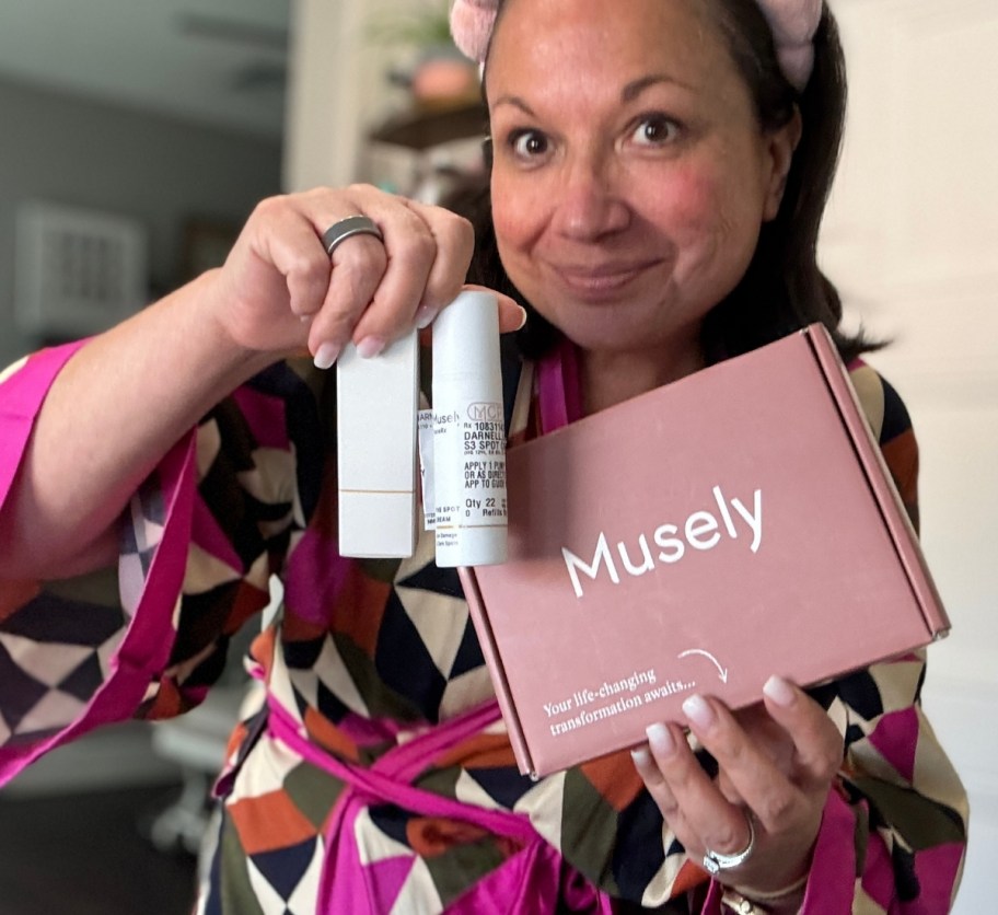 Woman with face cream bottle and shipping box