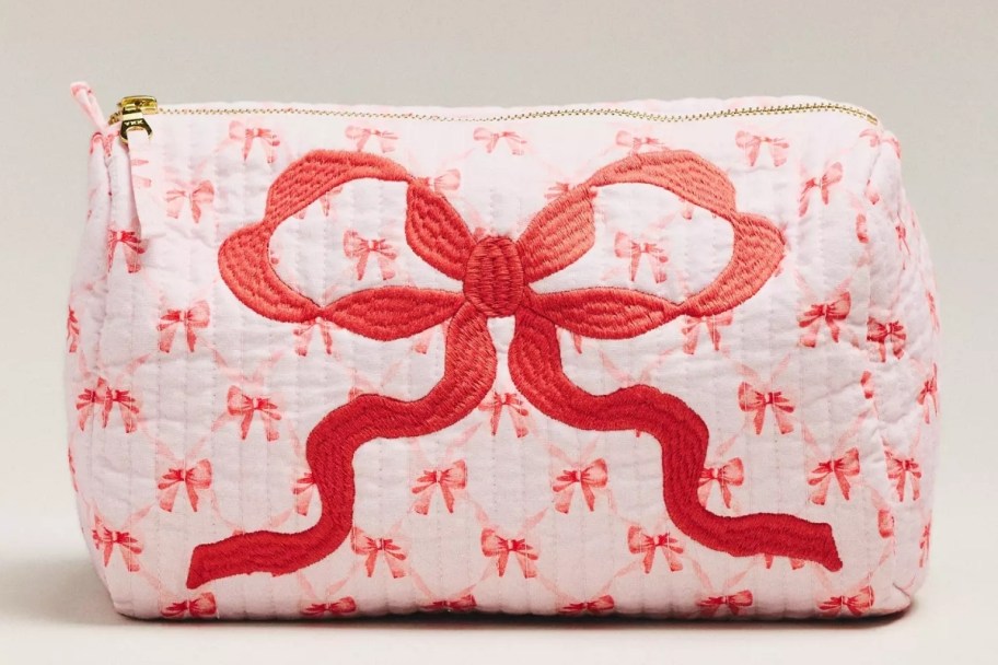 a zippered makeup bag with red bow print and embroidery
