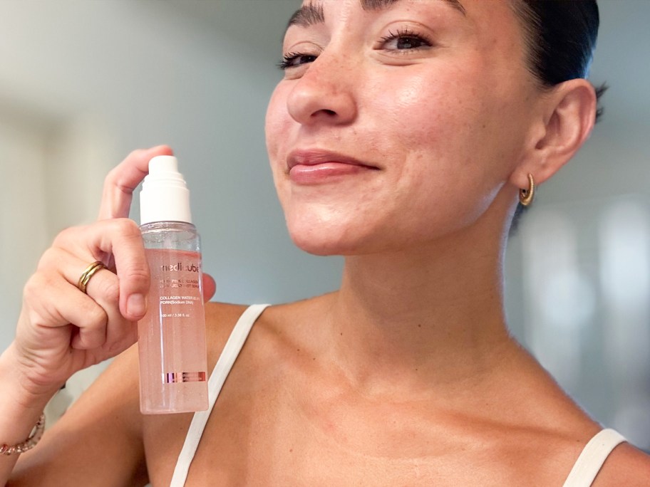 woman holding bottle of medicube Jelly Mist Serum