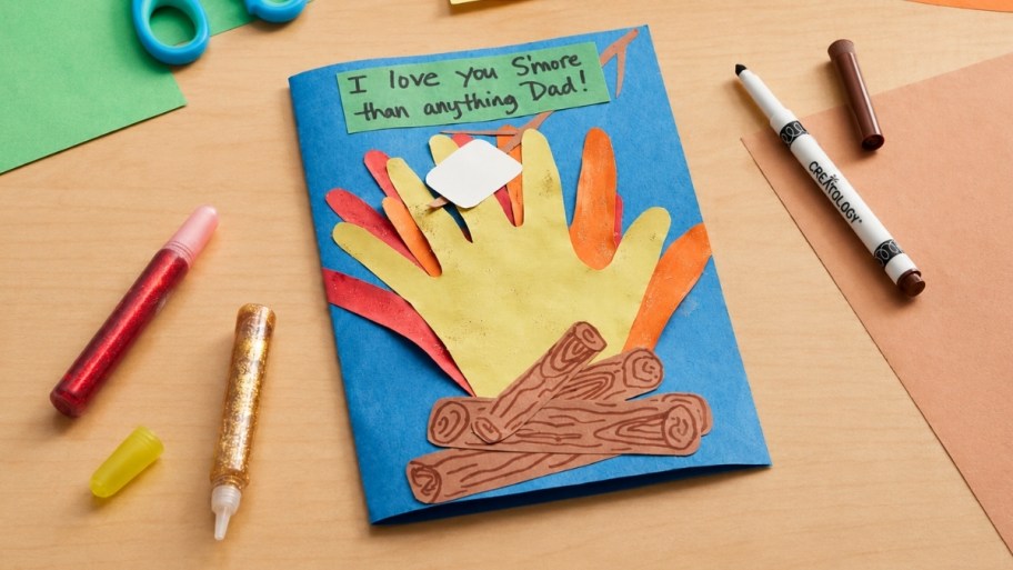 a fathers day card made from construction paper and glitter and crayons on a tabletop