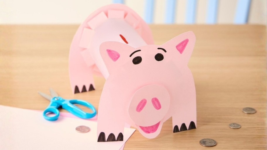 a construction paper piggy bank on a tabletop