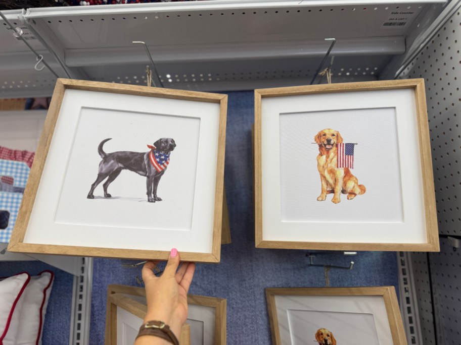 Framed artwork of two dogs. The left shows a black dog with an American flag scarf, and the right features a golden dog with a flag backdrop.