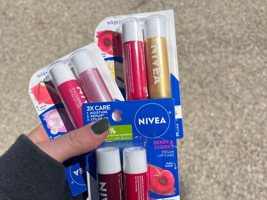 hand holing multipacks of nivea lip balms
