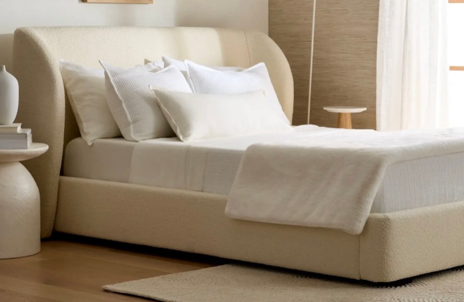 boucle bed with white linens and pillows in bedroom