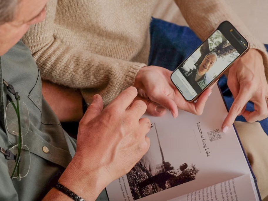 man holding a phone and looking at a book