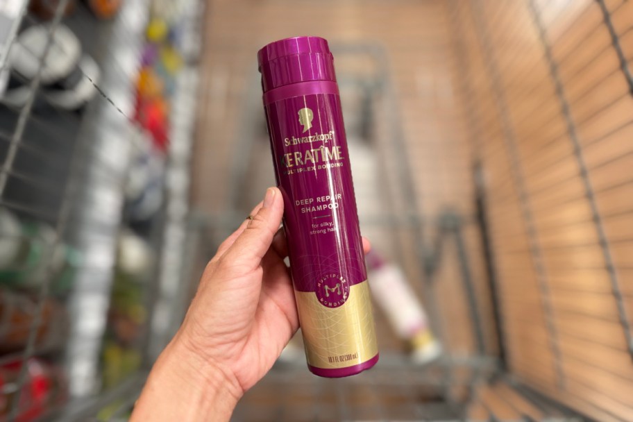 hand holding purple shampoo over cart