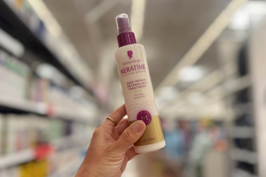 hand holding spray bottle up