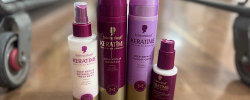 four purple haircare bottles on floor