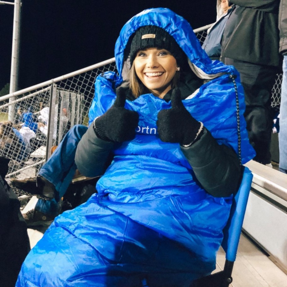 woman in blue sleeping bag giving thumbs up