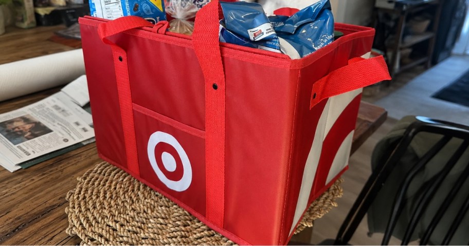 a red Target brand tote bag filled with groceries on a dining room table
