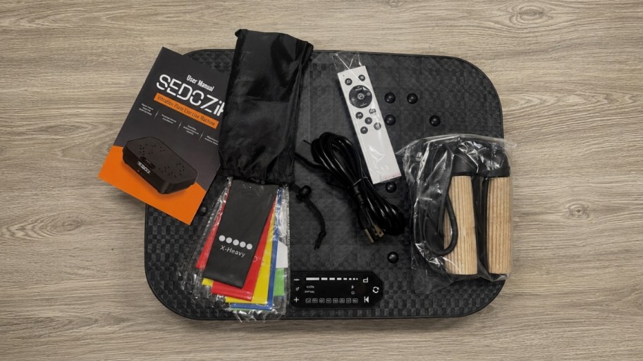 a vibration plate shown with accessories including resistance bands