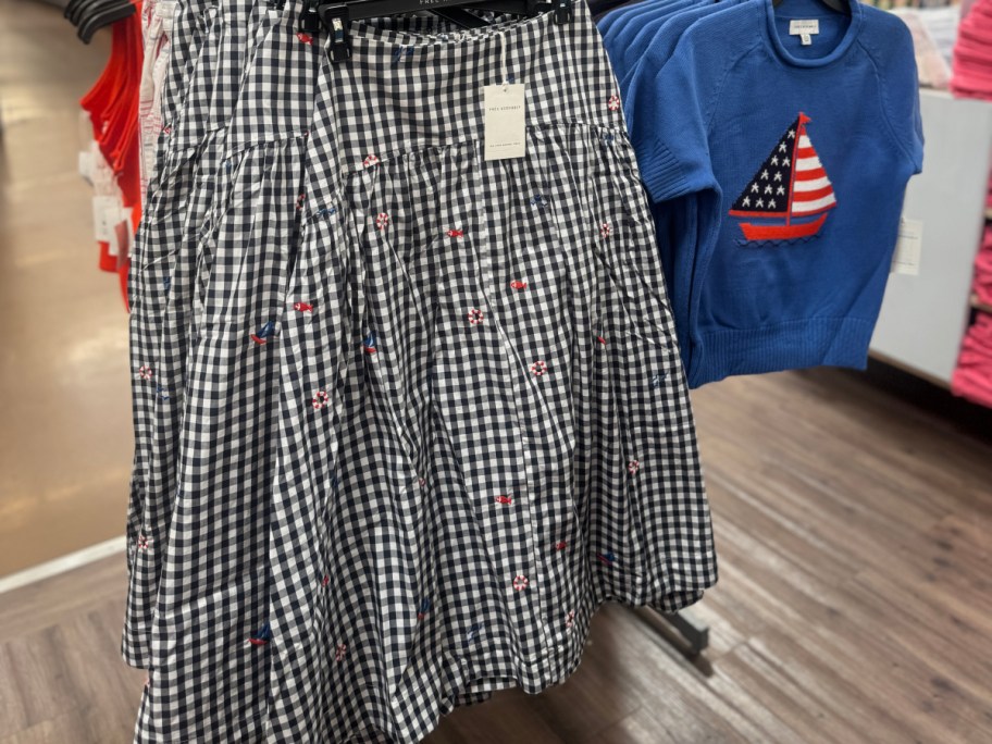Checkered black and white skirt with small red and blue floral patterns on a rack.