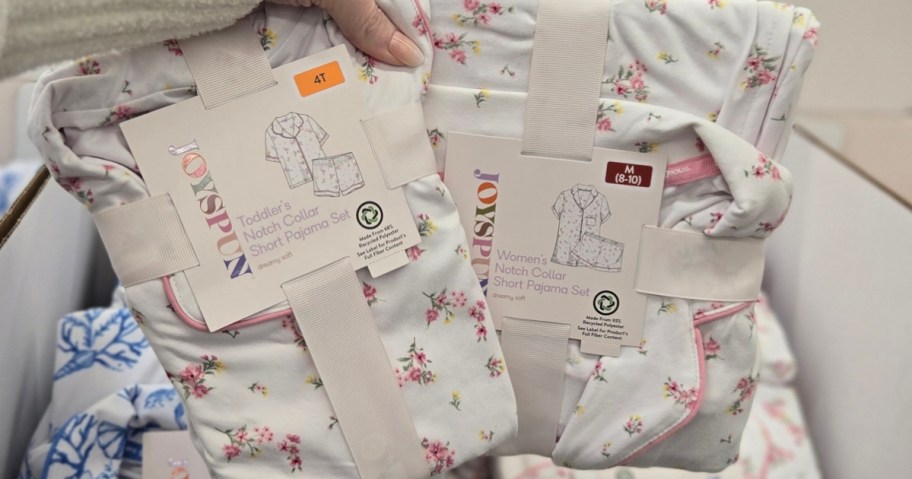 hand holding two matching pairs of women's and kids pajamas