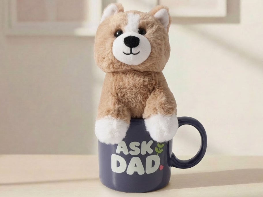 a coffee mug that says "ask dad" with a dog plush sitting in it