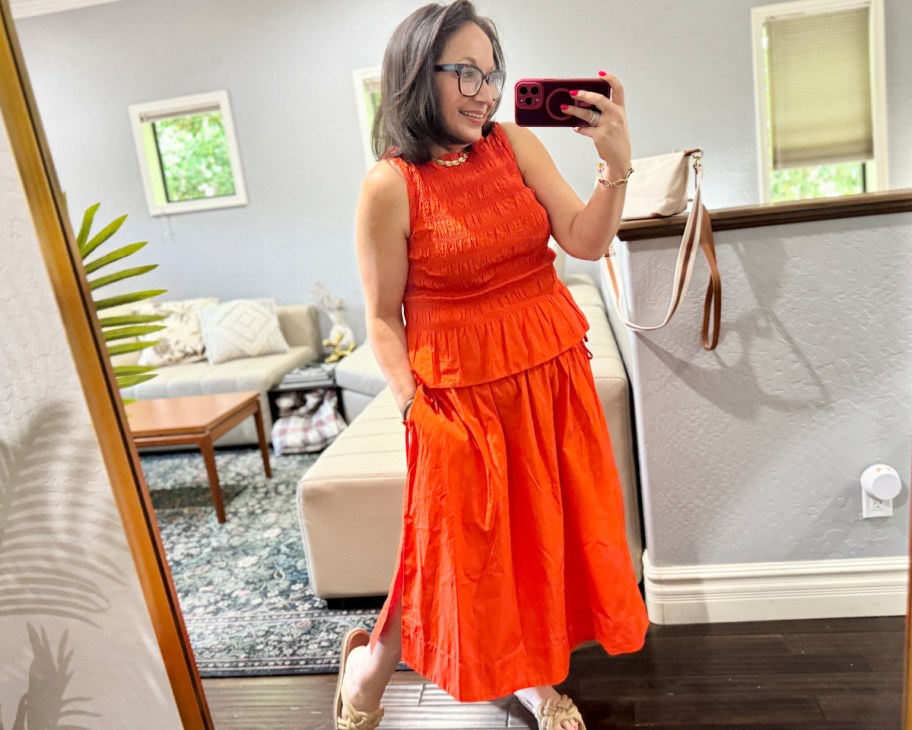 woman taking selfie in red dress and skirt
