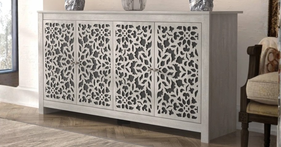 a large sideboard cabinet with cutout details on the doors