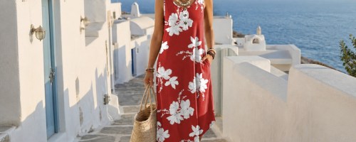 woman wearing red floral midi dress with what buildings and ocean in background