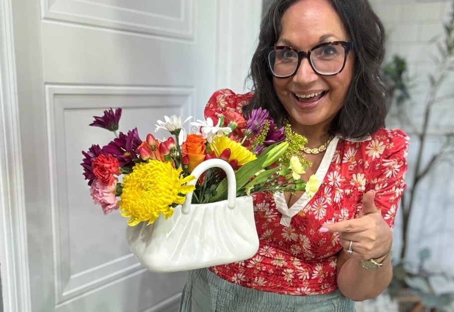 woman with a floral arrangement in a purse vase