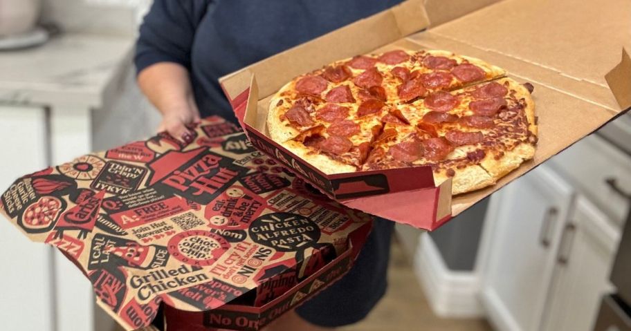 Woman holding two Pizza Hut pizzas