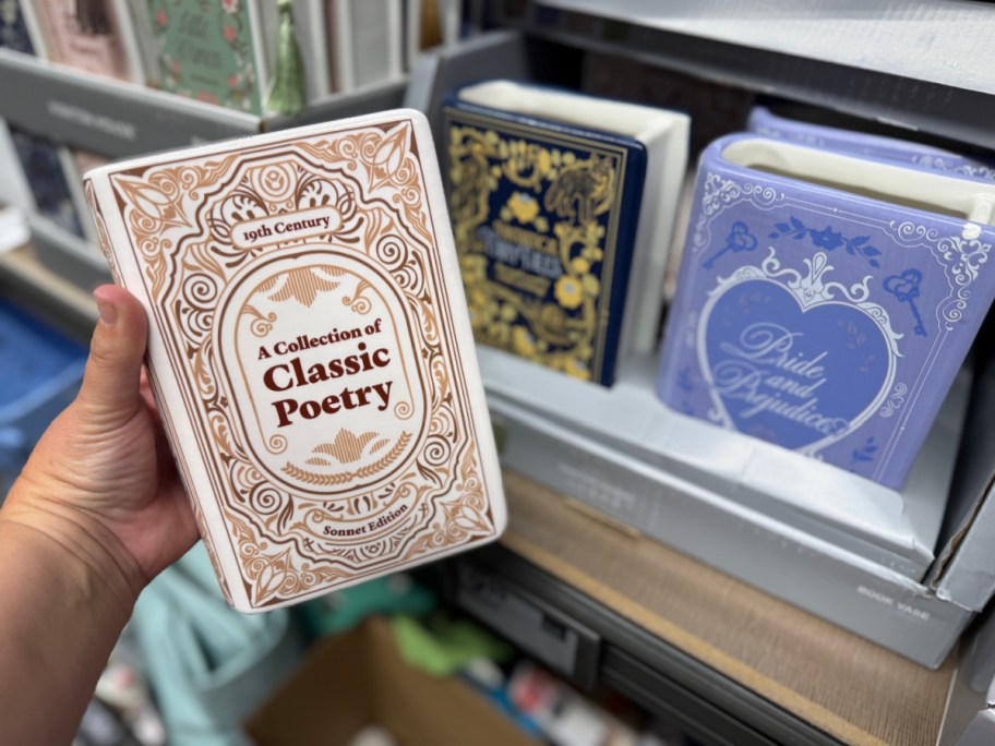 hand holding book candle near shelf