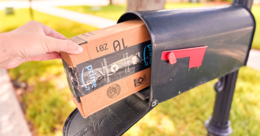 Hand taking Amazon prime box out of black mailbox