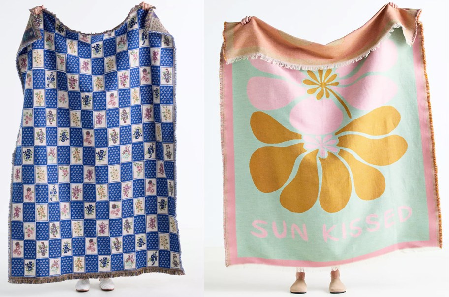 two people holding up printed blankets