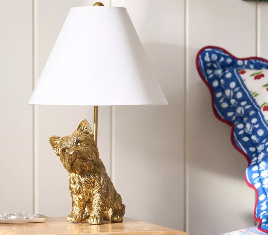 gold yorkie table lamp with a white lamp shade