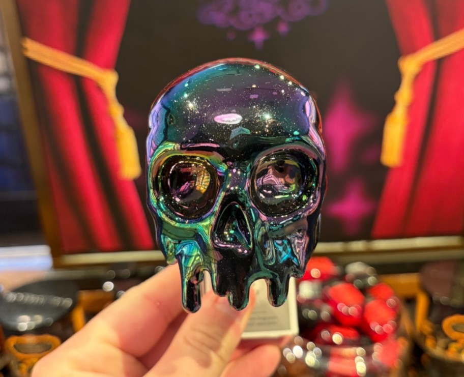 a hand holding a skull scent plug