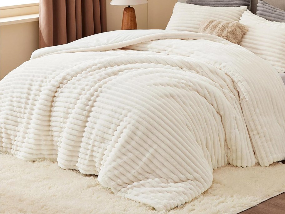 white striped comforter set and shams on a bed