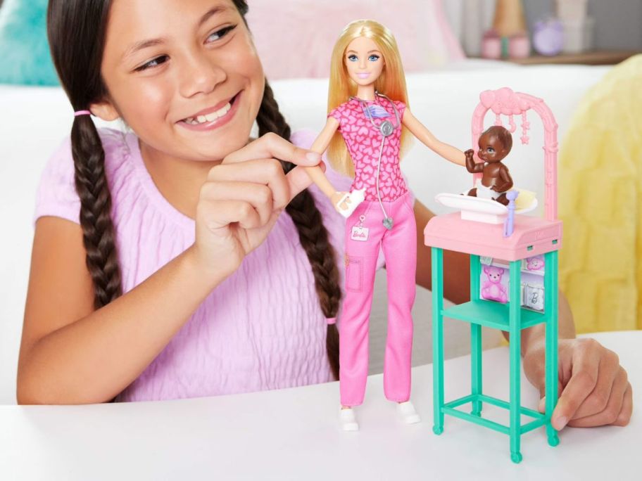 kid playing with Barbie Baby Doctor Doll