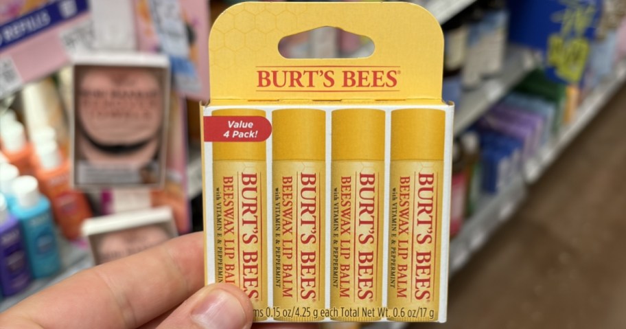 person holding a pack of burt's bees lip balm in store