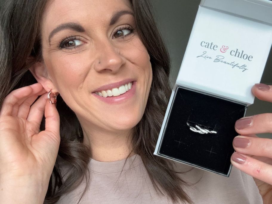 Woman wearing Cate & Chloe Lauren Hoop Earrings while holding a second pair in a Cate & Chloe Gift Box