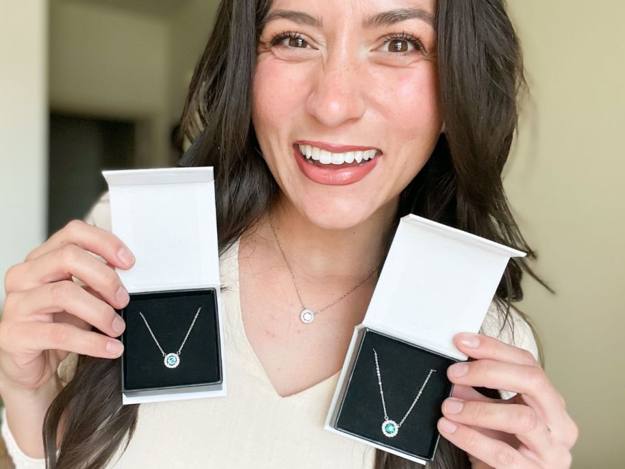 Woman wearing a Cate & Chloe Royal Birthstone Necklace while holding two additional Cate & Chloe Gift Boxes with Royal Necklaces in them
