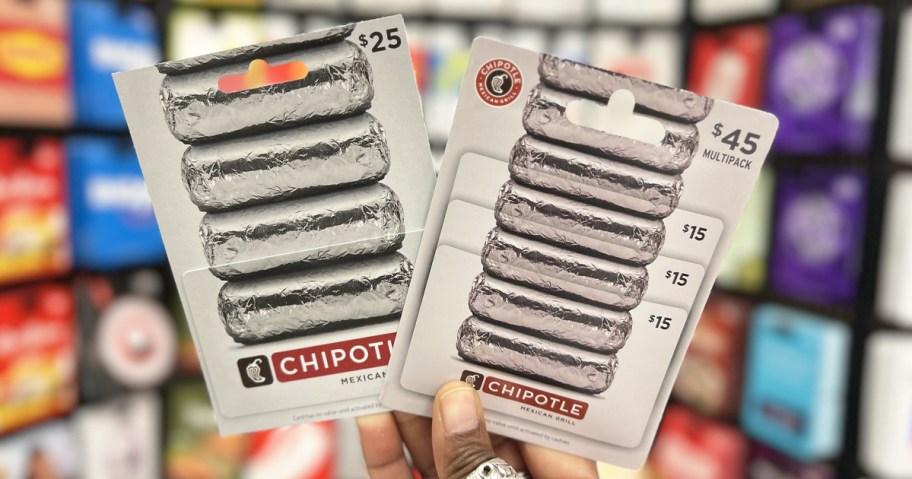 hand holding two Chipotle Gift Cards in store