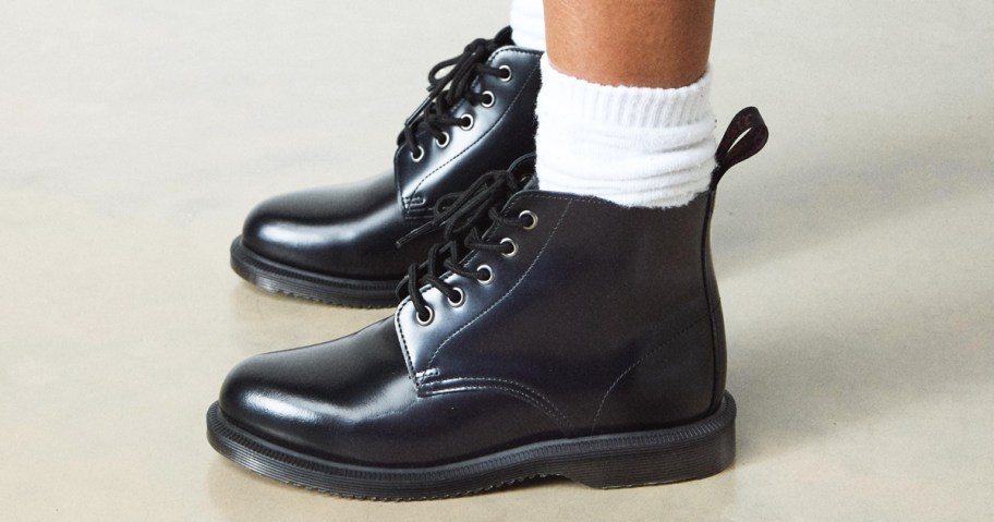 person wearing black leather boots