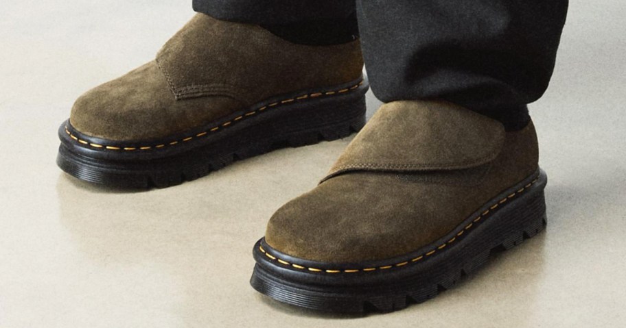 person wearing olive green suede mules