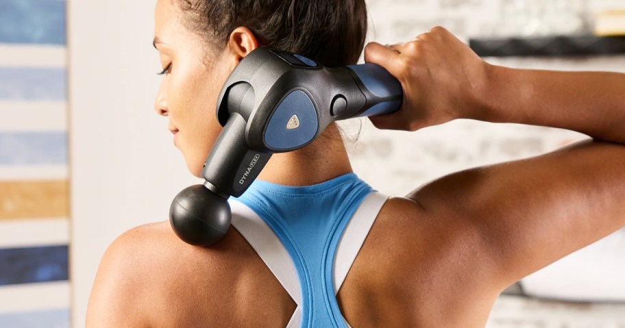 woman using massage gun on her back