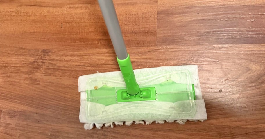 green sweeper mop on a wood floor